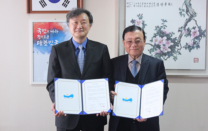 기증서를 펼쳐들고 사진을 찍은 모습
