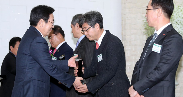 일렬로 서있는 수상자에게 상을 건내주는 모습