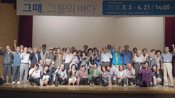 수료식을 마친 사람들이 강당에 모여 카메라를 바라보며 찍은 사진